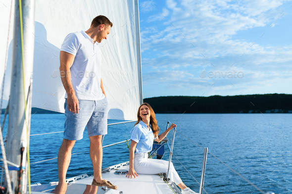 Couple Relaxing On Yacht Deck Spending Summer Sailing In Sea