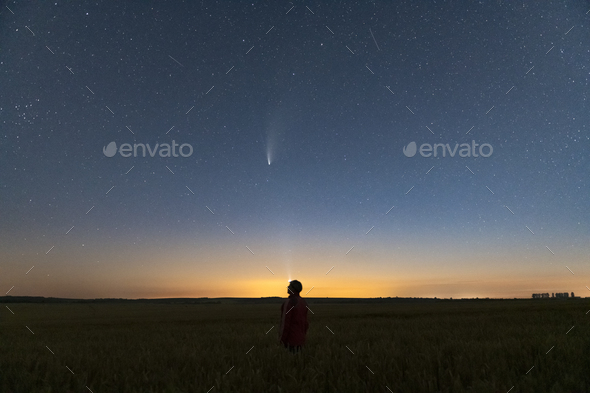 Silhouette of a man standing at night in a field outside the city