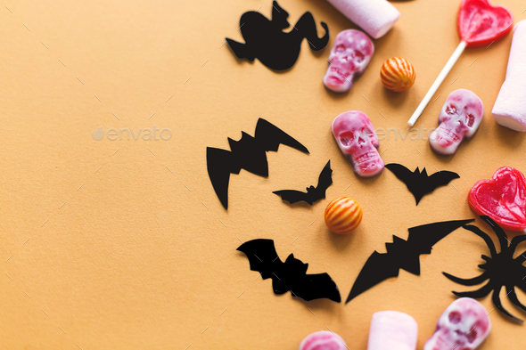 Halloween candy, skulls, black bats and ghost paper decorations