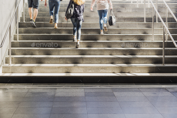 Four people walking up stairs Stock Photo by astrakanimages | PhotoDune