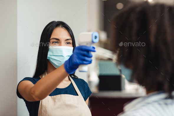 Beauty salon worker checking client body temperature before procedures