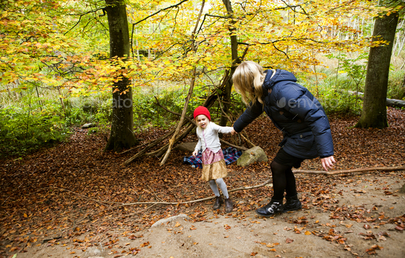 Playful mother and daughter in forest during autumn Stock Photo by ...