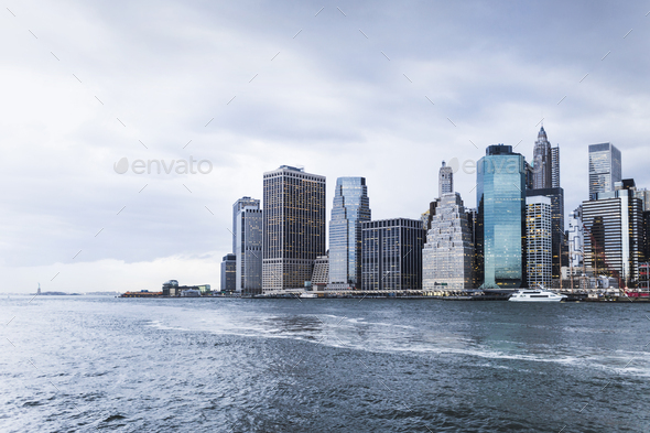Scenic view of East River and city against cloudy sky