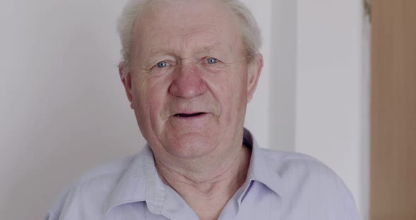 Happy Cured Grandfather Speaking at Camera and Showing a Thumb Indoor alt