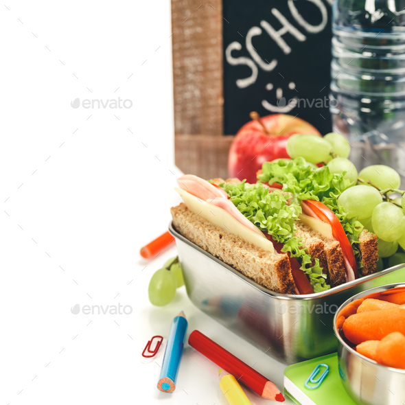 Lunch box with sandwich and fruits infront of chalk board,