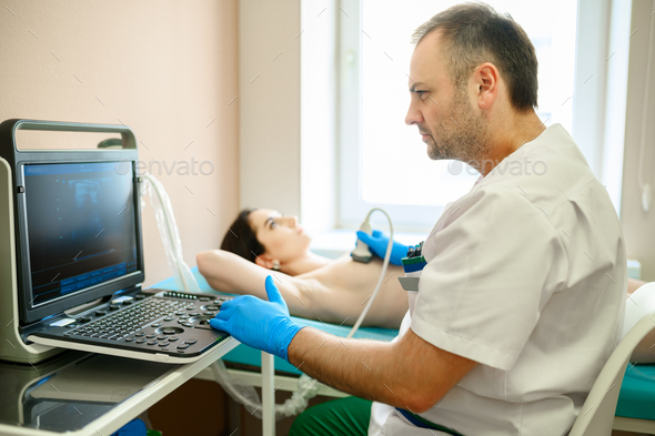 Male mammologist makes breast ultrasound scanning - Stock Photo - Images