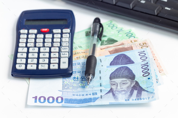 Different value South korean currency bill near calculator pen and keyboard, save money concept
