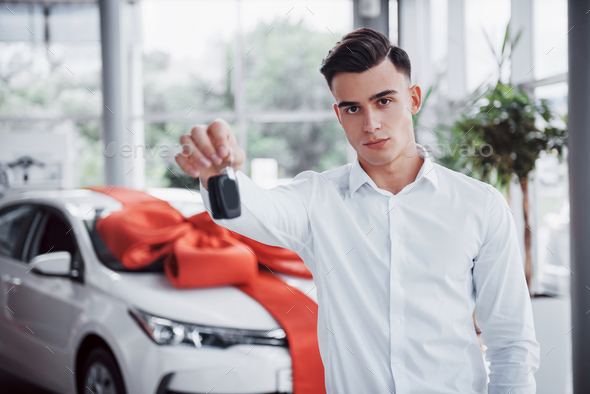 Happy young man with keys in his hands, lucky buy a car.