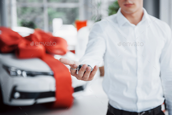 Young business man with keys in his hands, buys a car in the cabin