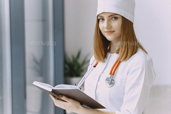 Smiling medical doctor woman with stethoscope. Isolated over white background. Image of an enthusiastic intern looking at camera
