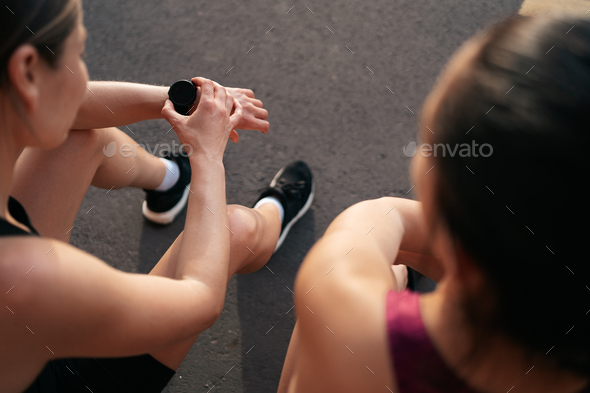 Portrait of two young beautiful sport woman resting after workout in the city