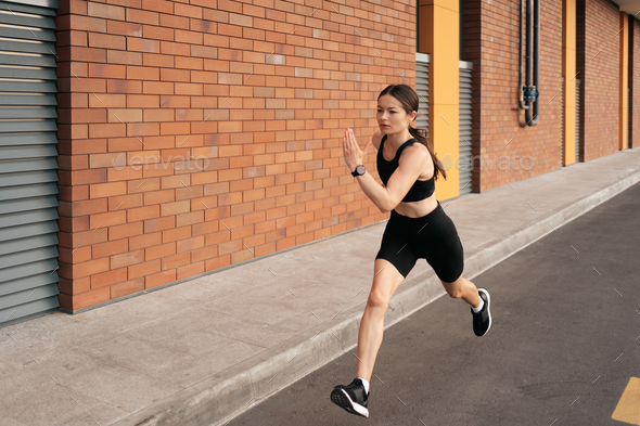 Female fitness model training outside in the city Stock Photo by diignat