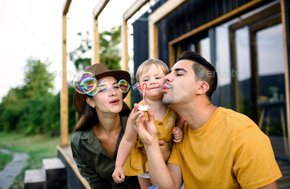 Young family with small daughter outdoors, weekend away in container house in countryside - Stock Photo - Images