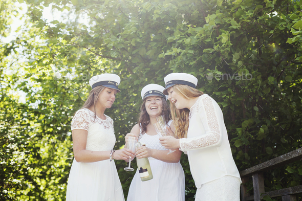 Cheerful university students enjoying champagne at graduation party