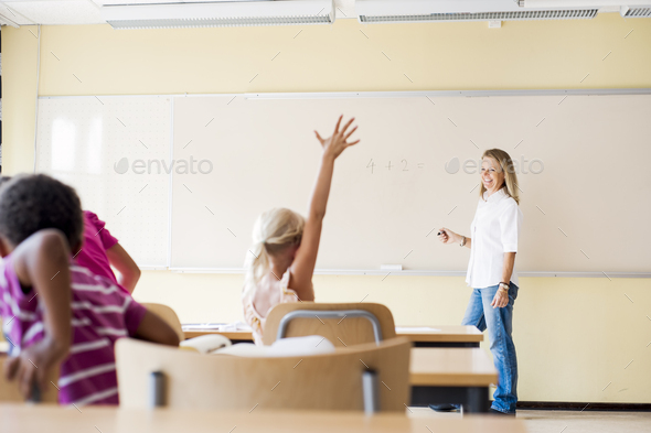 Elementary student raising hand in math class