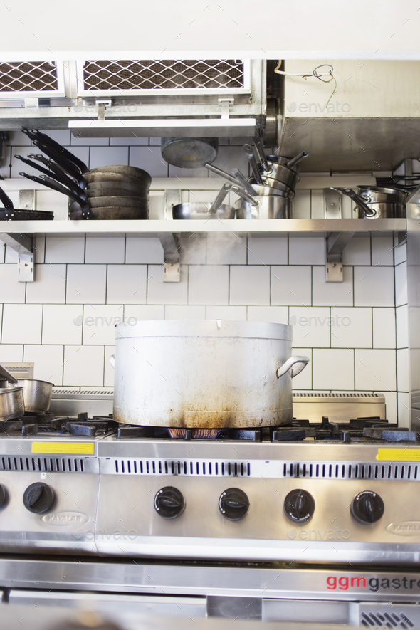 Metal container on stove at commercial kitchen