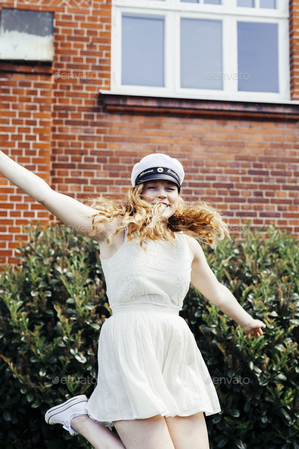 Portrait of cheerful university student jumping at graduation party