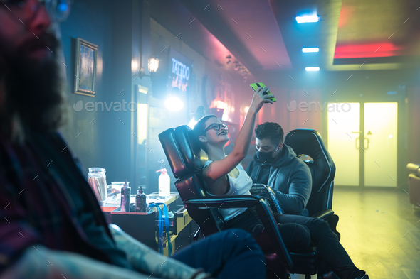 Girl Taking Selfie for Social Media While Getting Tattoo done - Stock Photo - Images