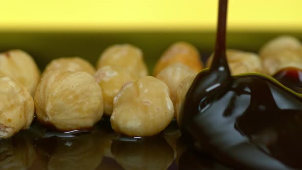 Pouring Dark Chocolate on Hazelnuts