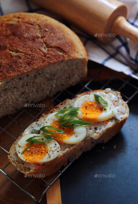 Open faced sandwich sourdough bread with sliced egg yolk Stock Photo by