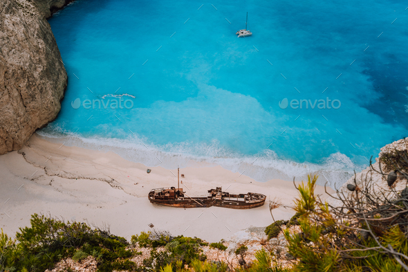 Shipwreck on Navagio beach. Azure turquoise sea water and paradise sandy beach in evening light - Stock Photo - Images