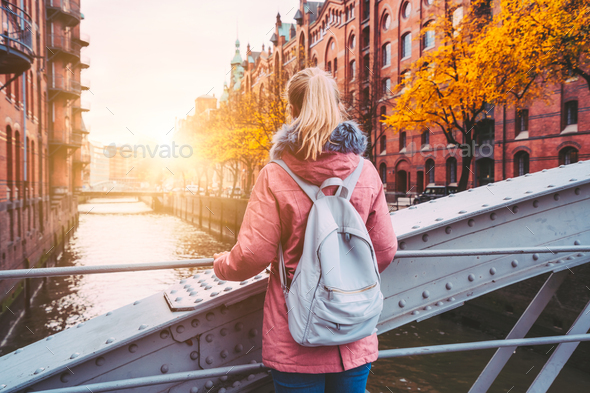 Back rear view of adult blond woman tourist with backpack enjoying autumn beautiful sunset scene on - Stock Photo - Images