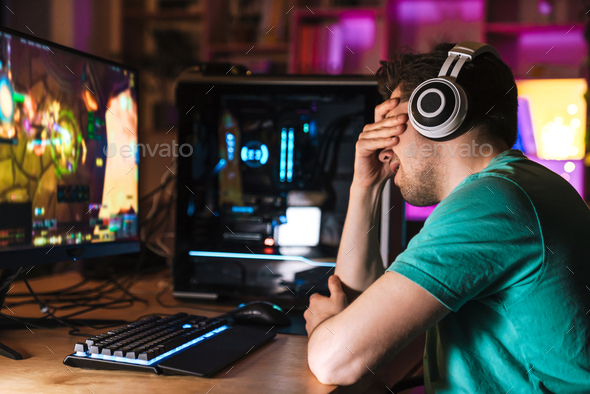 Image of unhappy young man crying while playing video game Stock Photo ...