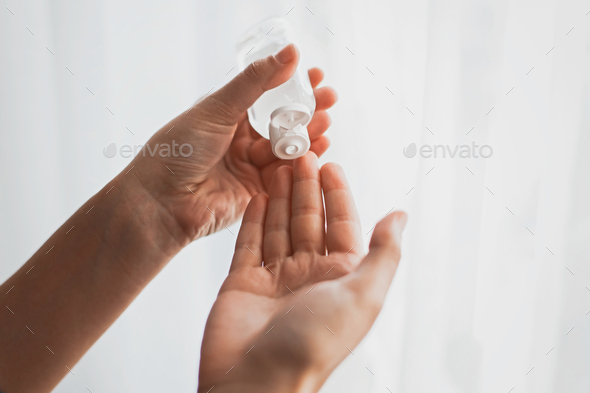 Taking disinfection alcohol gel on hands in white light