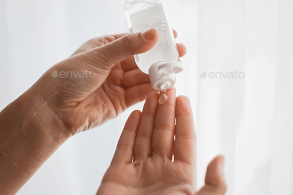 Taking disinfection alcohol gel on hands in white light
