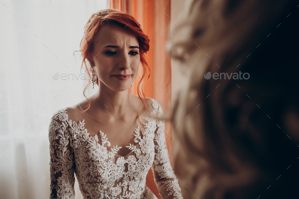 Stylish happy bride crying looking at mother