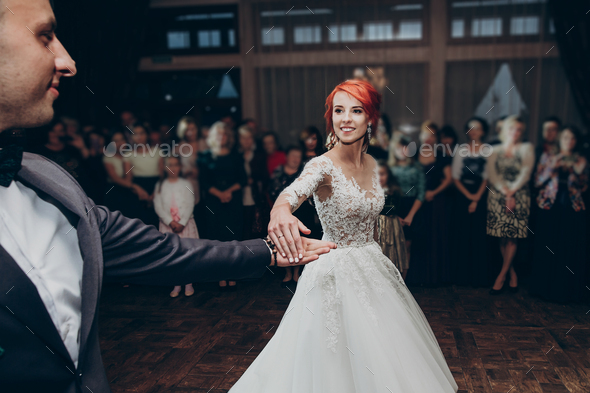 happy bride and stylish groom dancing at wedding reception. gorgeous wedding couple performing their first dance in restaurant. newlyweds, happy emotional moment. space for text