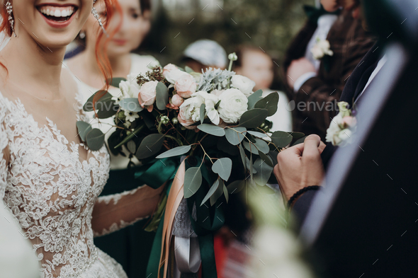 Stylish happy bride holding modern bouquet
