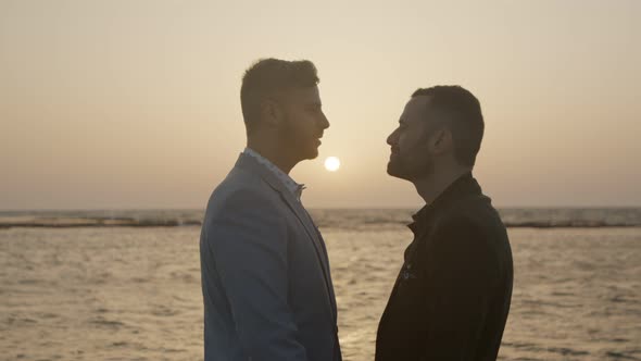 Gay couple together on the beach during sunset alt