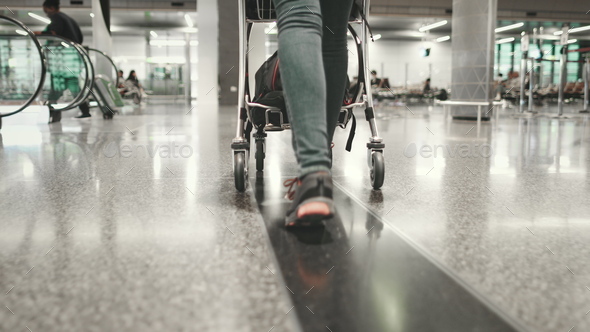 woman carry luggage cart walk at airport terminal