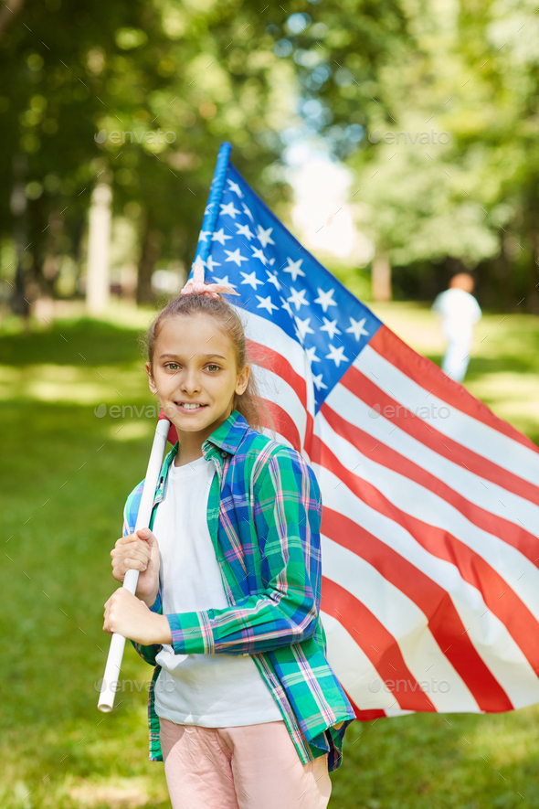 Smiling Girl Holding American Flag in Sunlight
