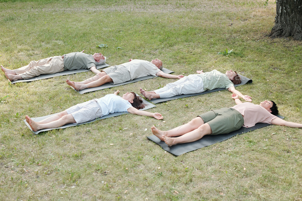 Group of yoga students lying in corpse pose