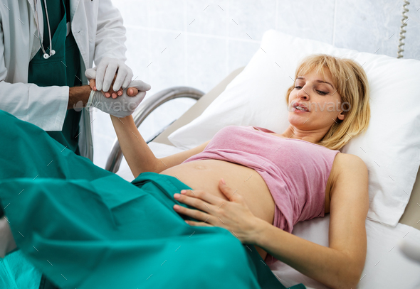 Pregnant beautiful woman with doctor in maternity hospital before childbirth