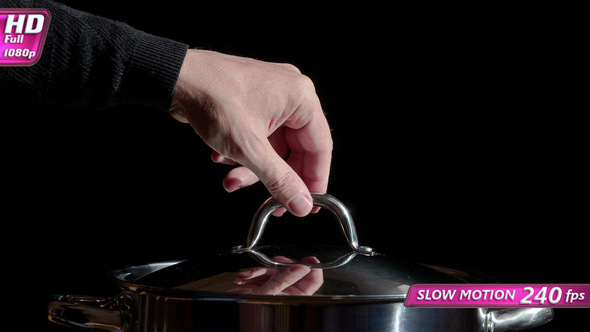 Cook Picks Up The Lid From The Pan alt