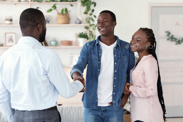 Male Family Therapist And Happy Black Couple Handshaking In Office After Meeting, Spouses Grateful To Counselor