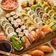 Above view of various sushi and rolls placed on wooden board. Japanese food  fest Stock Photo by Daniel_Dash