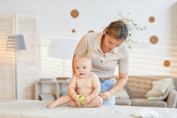 Mother Changing Clothes Of Baby