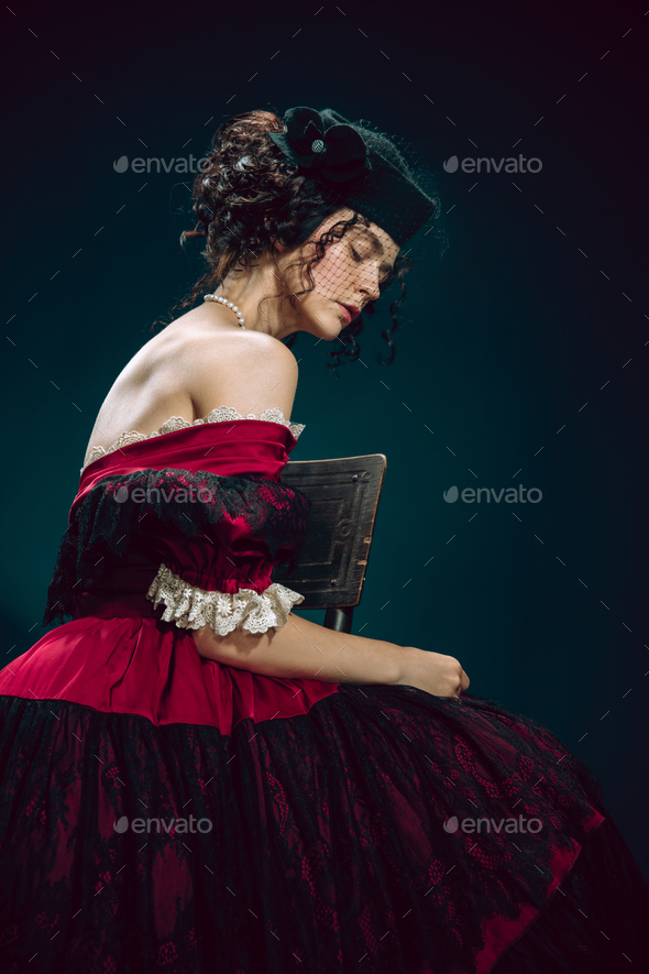 Young woman as Anna Karenina on dark blue background. Retro style, comparison of eras concept