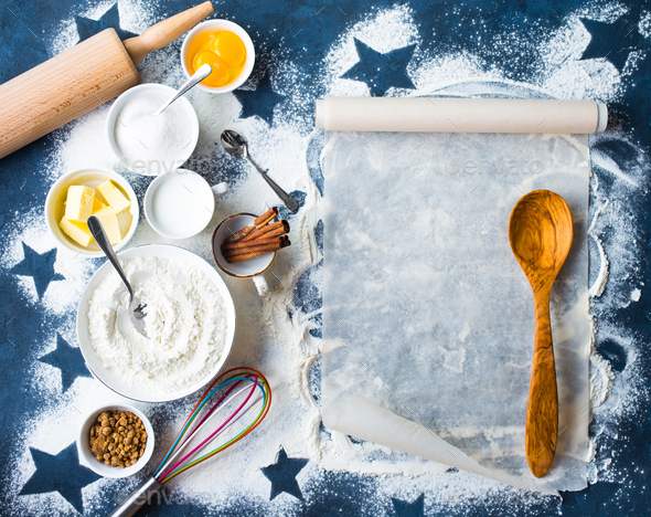 Baking background. Flour, sugar, eggs, butter, milk, cinnamon sticks, whisk, rolling pin, baking paper. Space for text. Ingredients for baking. Kitchen utensils. Top view. Making baked goods. Concept