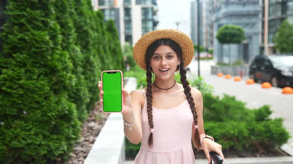 Woman Showing Modern Smartphone with Green Screen for Replacement alt