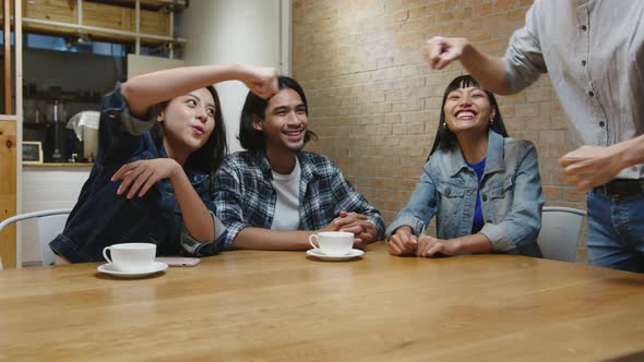 Young Asian friends having fun a great time and greeting with friendship fist pump at cafe. alt