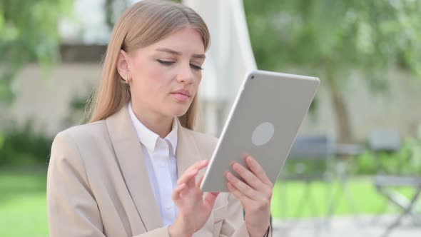 Outdoor Young Businesswoman Browsing Internet on Tablet alt