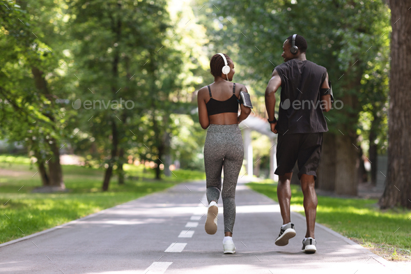 Morning Jogging. Active Black Couple In Sportswear Running In Summer Park, Rear View With Free Space
