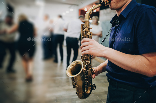 Musician playing sax at wedding reception in restaurant