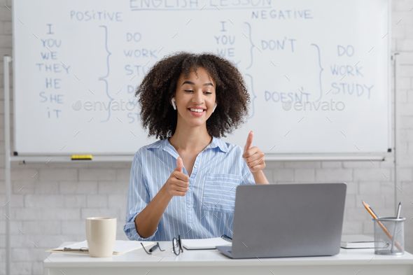African american woman showing thumbs up, puts excellent rating for student results
