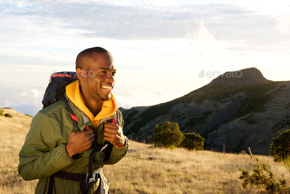 smiling young black man hiking in mountains with backpack bag Stock ...